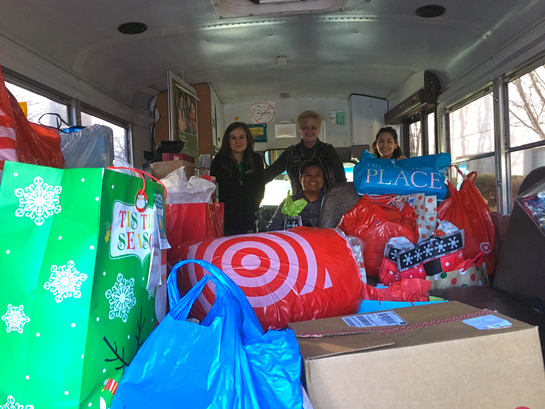 People standing in a bus with gifts