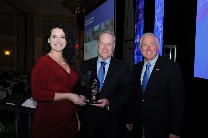 3 people holding an award